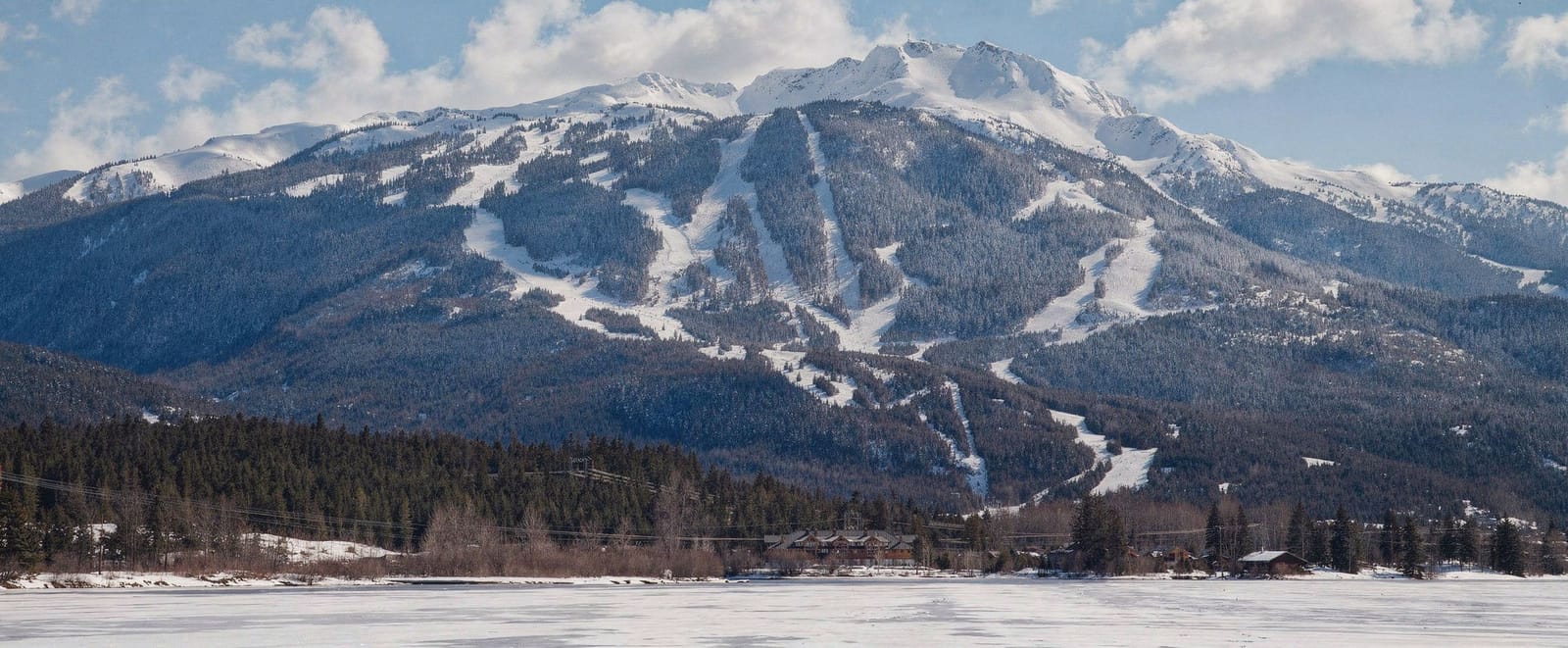 The sheer granite face of the Stawamus Chief rising above the highway, photographed from the water on a clear morning.